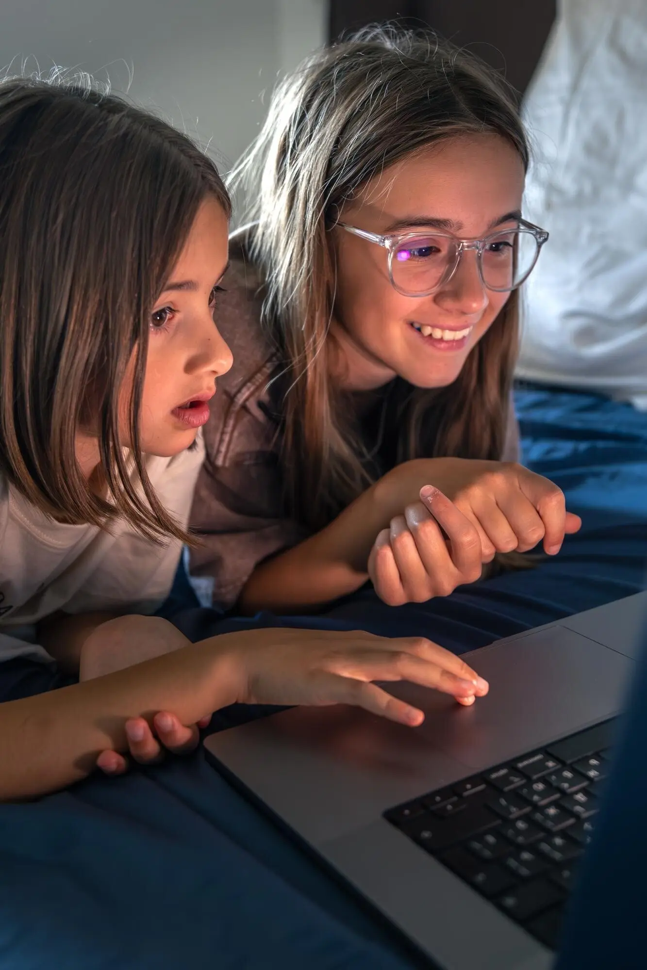 Девушки у ноутбука празднуют находку; на экране — счастливая девушка.