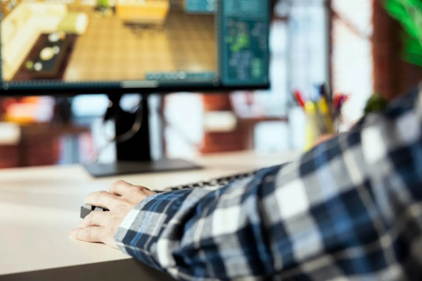 Крупный план: мужчина в домашнем офисе расставляет мебель в CAD‑программе.